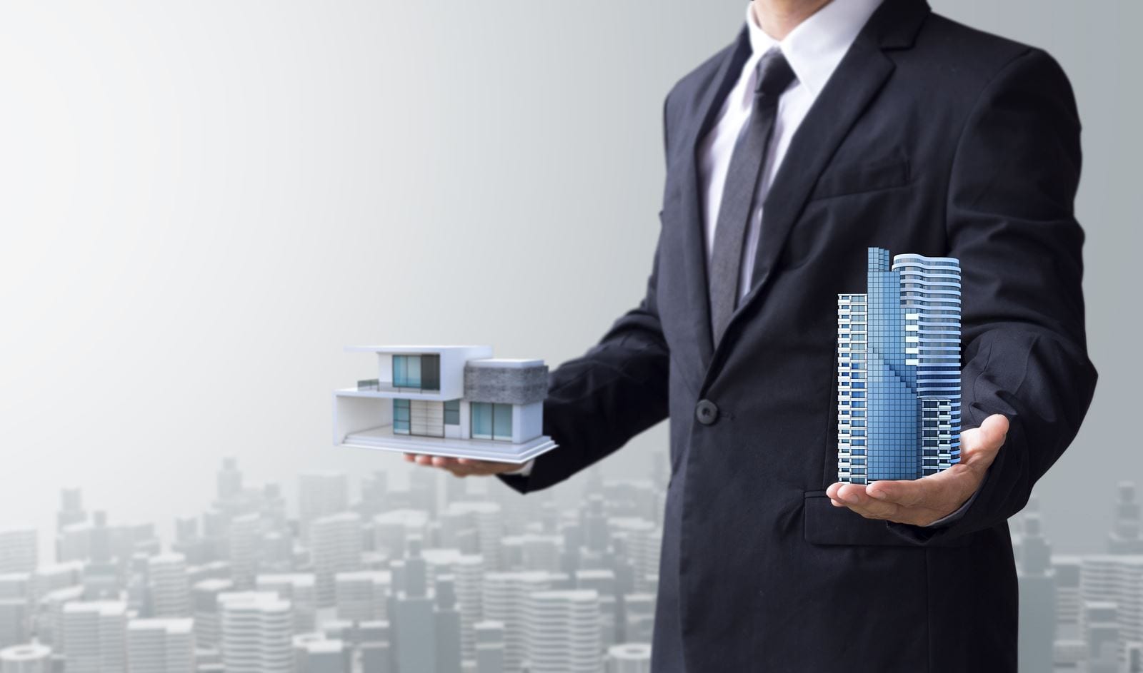 a man holding a model of a building