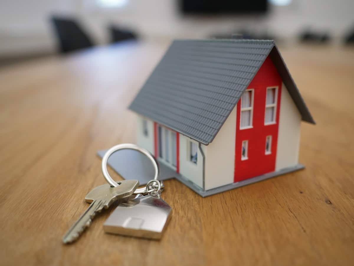 Clés de maison posées sur table en bois avec papiers immobiliers